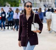 Modelo exibe cinco peças minimalistas: blazer vinho, jeans claros e bolsa branca
