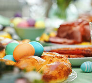 Almoço de Páscoa: família reunida com ovos coloridos, carne e pão