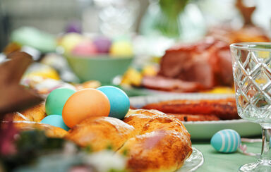 Almoço de Páscoa: família reunida com ovos coloridos, carne e pão
