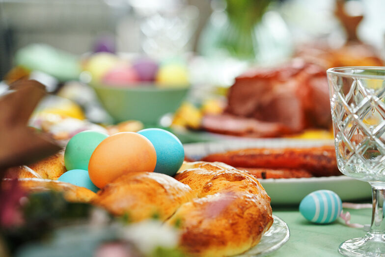 Almoço de Páscoa: família reunida com ovos coloridos, carne e pão
