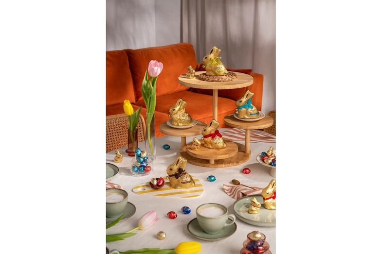 Mesa festiva com chocolates em forma de coelho e tulipas para celebrar a Páscoa