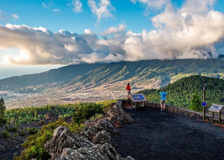 Pessoas apreciam a vista de montanha, num dia soalheiro, perto de Madrid