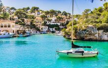 Porto com barcos e casas à beira-mar, destino popular de verão