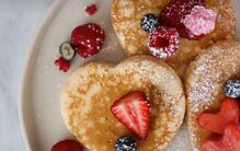 Celebre o Dia da Mãe com panquecas de coração e frutos vermelhos num brunch especial.
