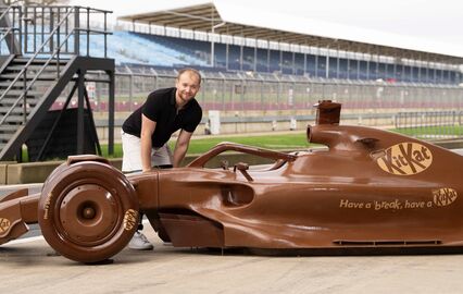 O piloto britânico Billy Monger junto de uma réplica de um carro da F1 feita de chocolate em Silverstone