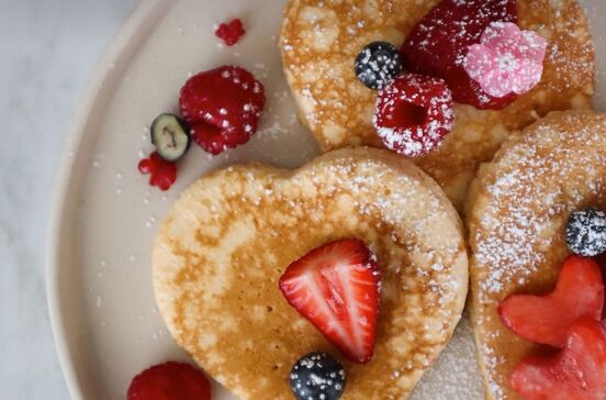 Celebre o Dia da Mãe com panquecas de coração e frutos vermelhos num brunch especial.
