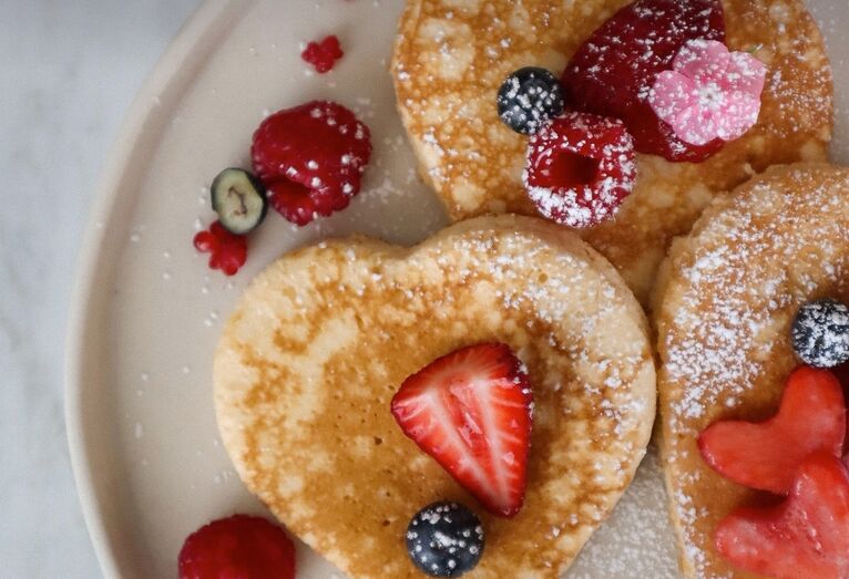 Celebre o Dia da Mãe com panquecas de coração e frutos vermelhos num brunch especial.
