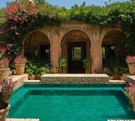 Piscina verde com arquitetura marroquina e plantas