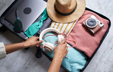 Mala de viagem pronta com roupa, acessórios e eletrónicos para as férias