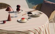 Mesa exterior com pormenores de verão: frutas, sobremesa e candeeiro