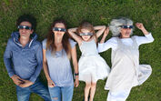 Família deita-se na relva a ver o eclipse com óculos especiais