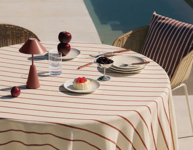 Mesa exterior com pormenores de verão: frutas, sobremesa e candeeiro