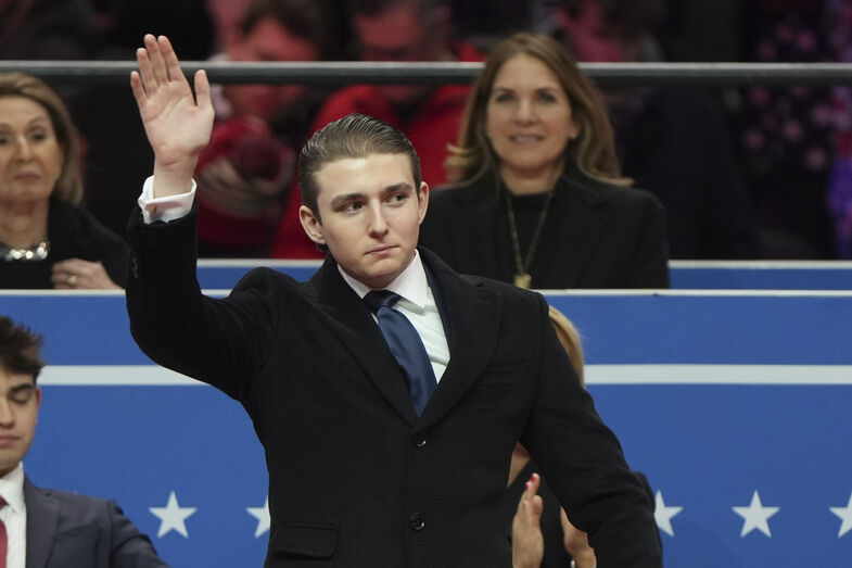 Barron Trump waves at an indoor Presidential Inauguration parade event in Washington, Monday, Jan. 20, 2025. (AP Photo/Matt Rourke)