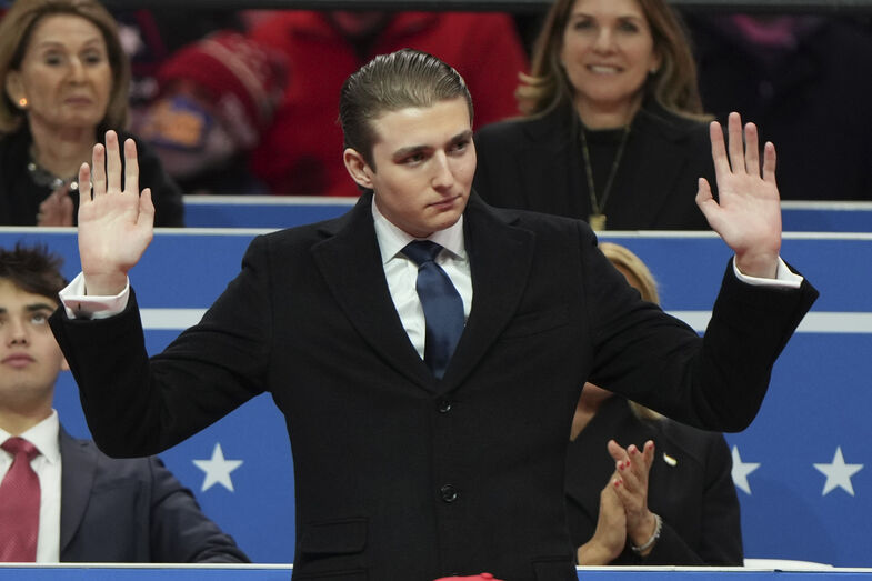 Barron Trump waves at an indoor Presidential Inauguration parade event in Washington, Monday, Jan. 20, 2025. (AP Photo/Matt Rourke)